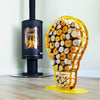 One of Ardour's light bulb shaped metal log baskets in honey yellow. It is a profile of a screw-in style light bulb attached to a base-plate. The design has two compartments; A small one at the top to store kindling and a large one for the main body of the bulb to store the logs.